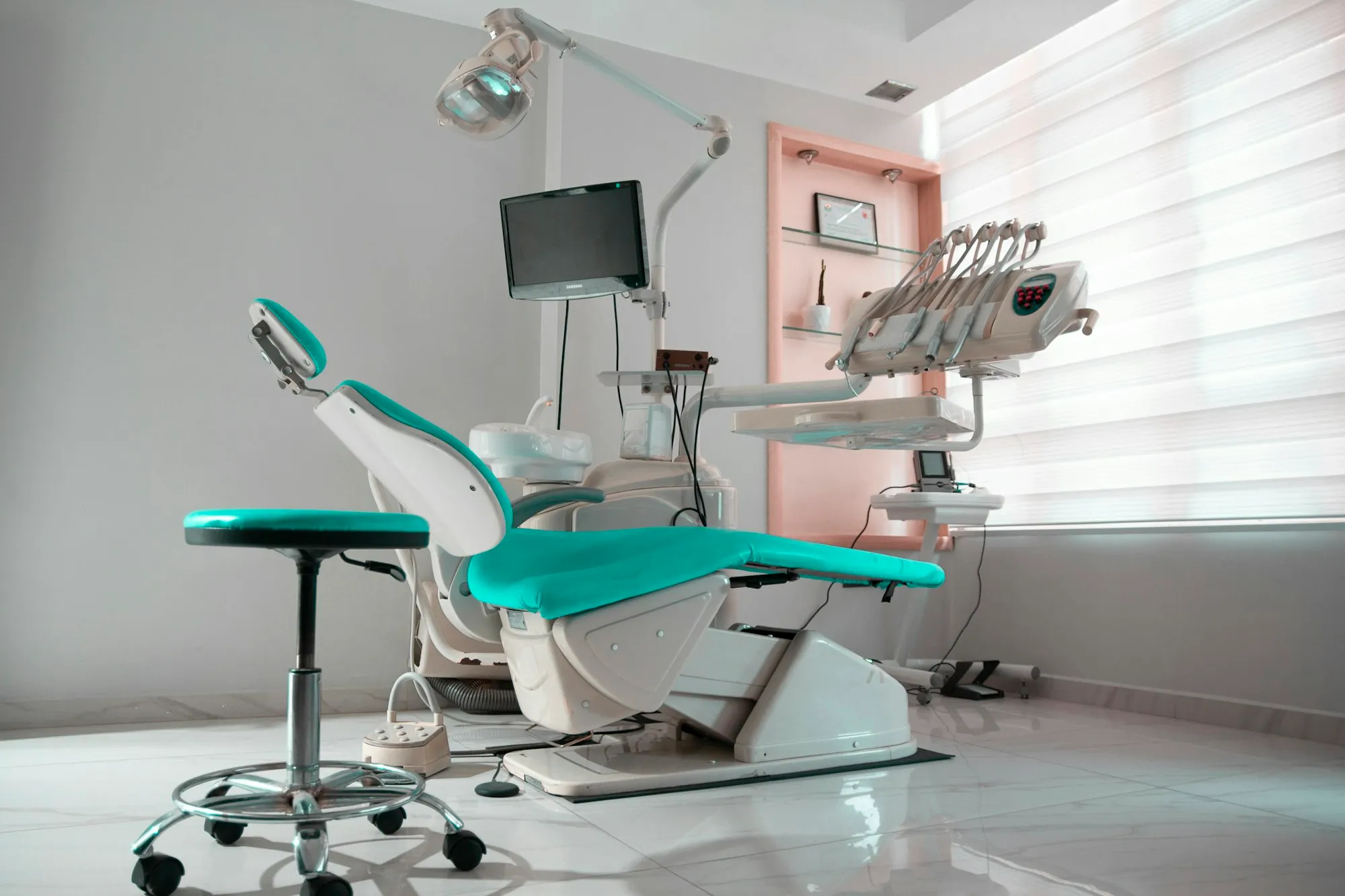 Wide view of a treatment room with monitor and dental unit