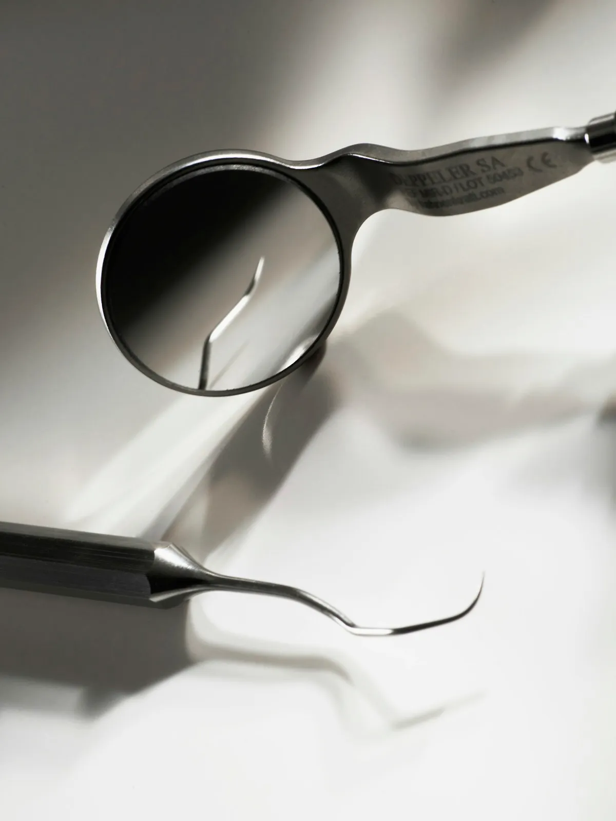 Dental mirror and explorer on a white surface